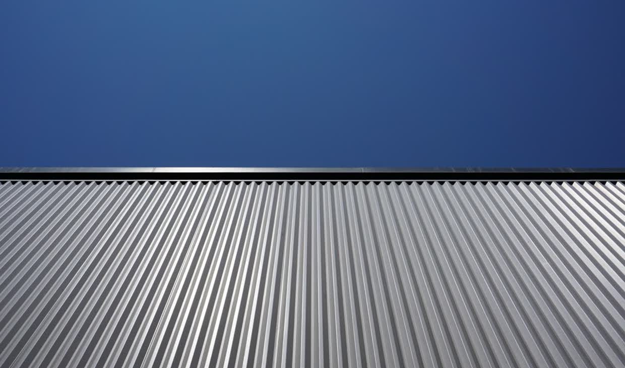 Metalldach mit Trapezprofil vor blauem Himmel
