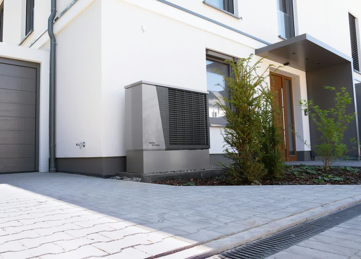 Luft-Wasser-Wärmepumpe an der Hauswand eines modernen Einfamilienhauses.
